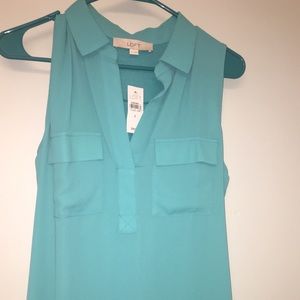 Teal sleeveless blouse.
